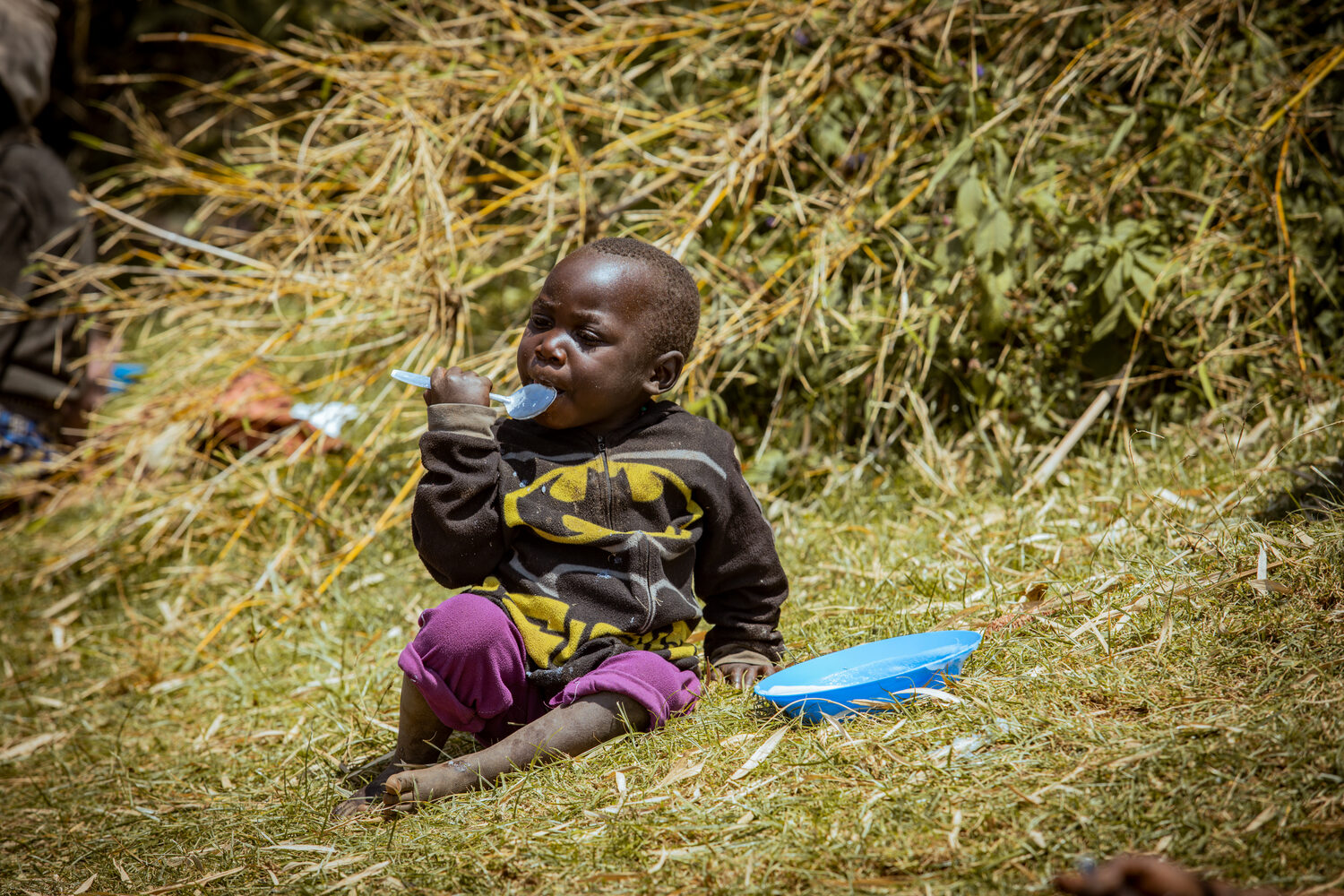 A child eating maize porridge provided by the team